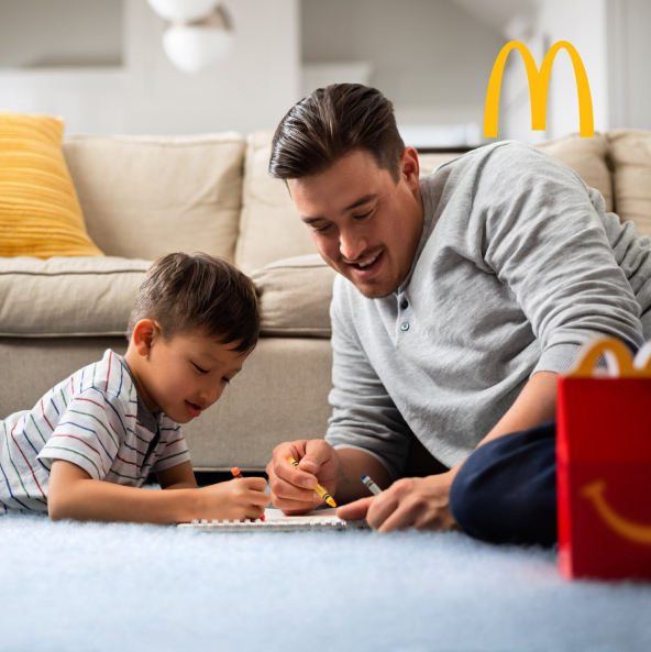 Father and son enjoying McDonald's in their living room.