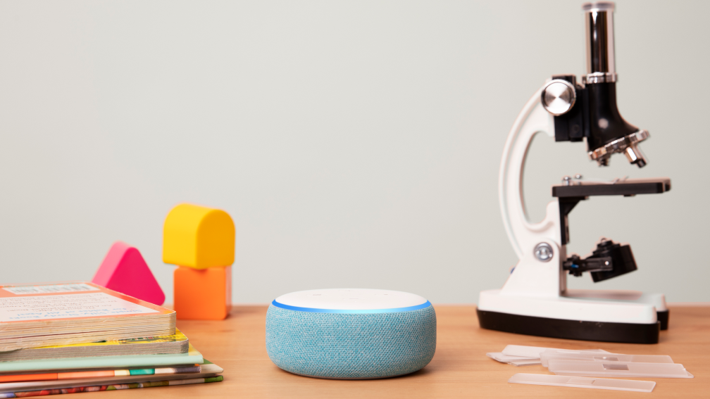 Blue Alexa speaker playing Hand Wash Tunes next to a white microscope.