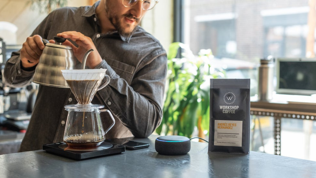Man brewing coffee in a V60 while listening to the Workshop Coffee Alexa guide