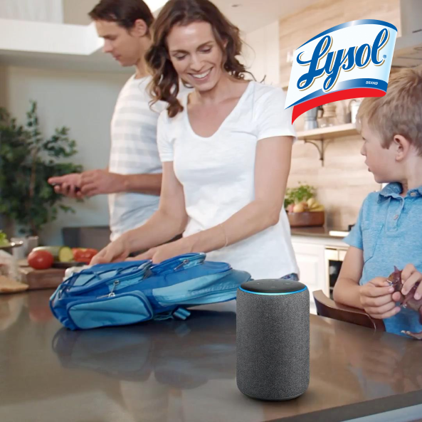 A woman in a kitchen packing a childs backpack with an Amazon Alexa device in the foreground